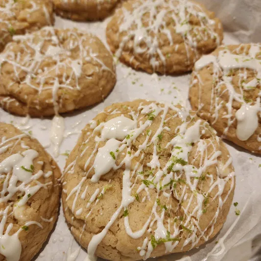 Key lime cookies topped with white drizzle and fresh lime zest