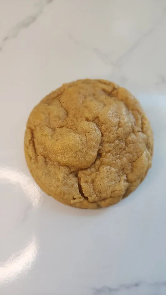 Soft golden peanut butter cookie on a marble surface