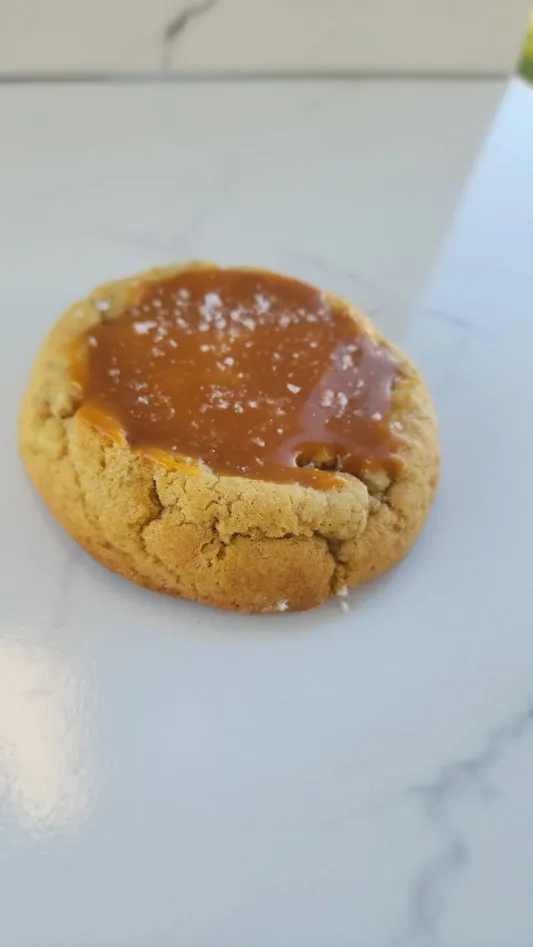Salted caramel cookie topped with glossy caramel and sea salt