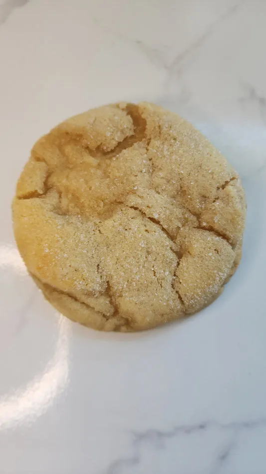 Soft sugar cookie with a sparkling sugar topping on a marble surface